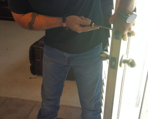 Locksmith installing door lock hardware